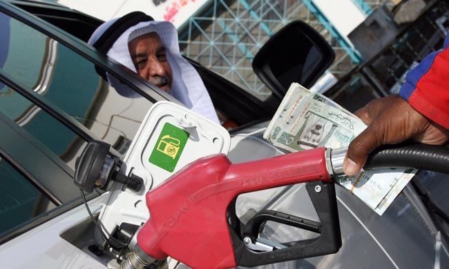 A foreign worker at a petrol station fills up a Saudi man's car north of Riyadh, 31 October 2007. The price of oil fell from record highs to below 90 dollars per barrel in Asian trade today as investors profited on expectations of an increase in US crude stocks, dealers said. AFP PHOTO/HASSAN AMMAR (Photo credit should read HASSAN AMMAR/AFP/Getty Images)